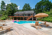 Thumbnail 10 of 16 - Affinitee at Stone Mountain Apartments photo of a swimming pool and a deck with chairs