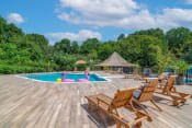 Thumbnail 6 of 16 - Affinitee at Stone Mountain Apartments photo of a swimming pool with deck chairs around it